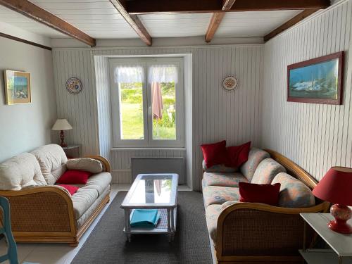 un salon avec deux canapés et une table dans l'établissement Maison bretonne traditionnelle en bord de Mer, à Plouguerneau