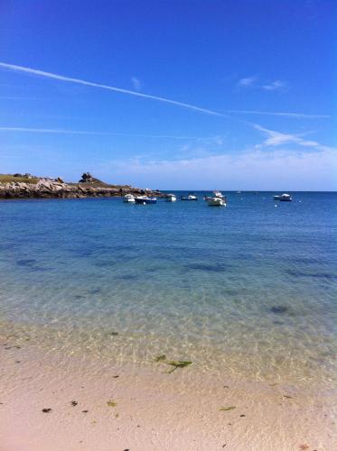 une plage avec des bateaux dans l'eau par temps clair dans l'établissement Maison bretonne traditionnelle en bord de Mer, à Plouguerneau
