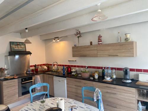 - une cuisine avec une table et deux chaises dans l'établissement Maison bretonne traditionnelle en bord de Mer, à Plouguerneau