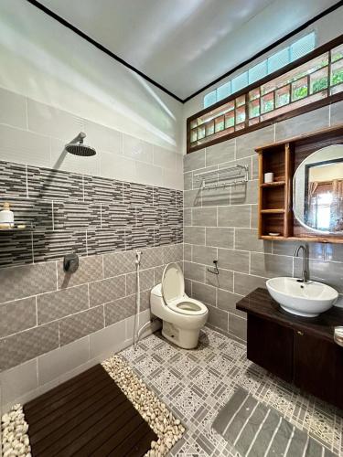 a bathroom with a toilet and a sink at Bunaken Villa Queen's Dive in Bunaken