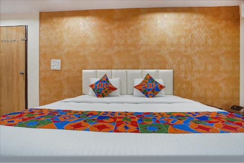 1 dormitorio con 1 cama grande y edredón colorido en FabHotel Olive Stay Inn, en Nagpur