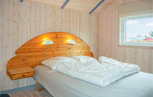 Bett mit einem Kopfteil aus Holz in einem Schlafzimmer in der Unterkunft 3 Bedroom Awesome Home In Sjlund in Hejls
