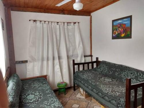 uma sala de estar com um sofá e uma janela em Hospedaje La Ushuta Negra em Amaicha del Valle
