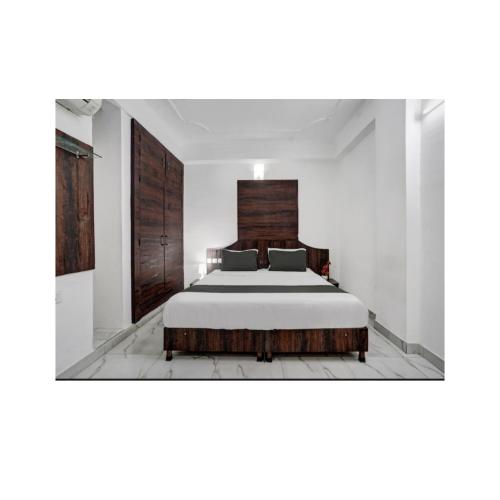 a bedroom with a large bed with a wooden headboard at HOTEL SKY HEIGHTS PALACE in Jaipur