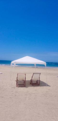 two chairs under a tent on a beach at PUNTA VELEROS ROOFTOP in Los Órganos