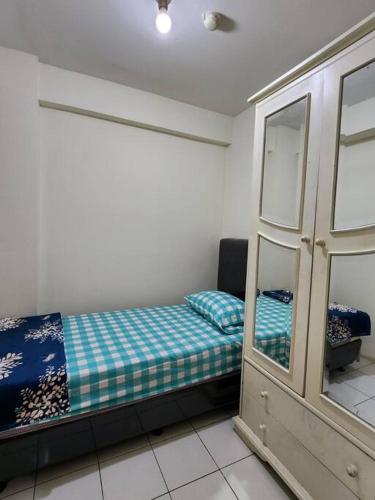 um pequeno quarto com uma cama e um espelho em Kalibata City,Tower Borneo, 2 Bed Rooms em Jakarta