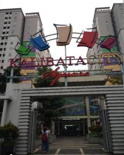 uma mulher em frente a um edifício com um cartaz em Kalibata City,Tower Borneo, 2 Bed Rooms em Jakarta