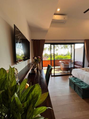a living room with a bed and a table with plants at Luxury Apartment at Lipah Beach in Ambat