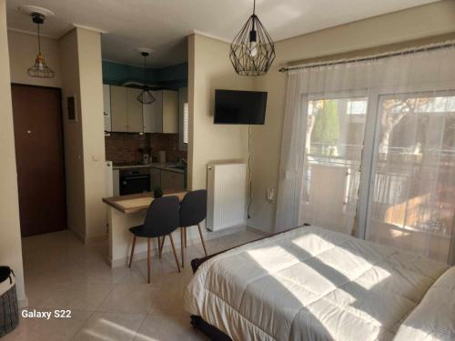 1 dormitorio con cama, mesa y cocina en George's Apartment en Volos