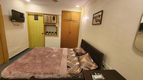 ムンバイにあるHome sweet home 3BHKの小さなベッドルーム(ベッド1台、テーブル付)