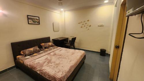 ムンバイにあるHome sweet home 3BHKのベッドルーム(ベッド1台、テーブル付)