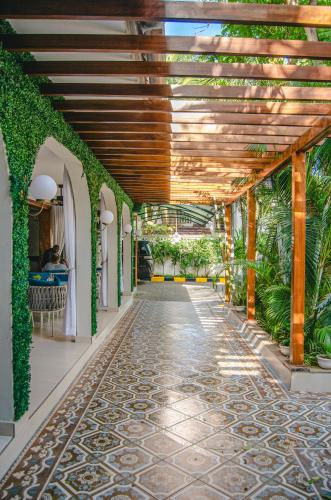 an indoor corridor with plants and a ceiling at La Fattoria Resort in Mombasa