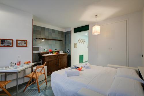 a bedroom with a bed and a table and a kitchen at Fiori di Miele - Happy Rentals in Bardonecchia