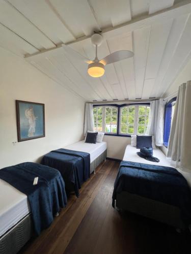 History Hostel في أورو بريتو: غرفة نوم بسريرين ومروحة سقف