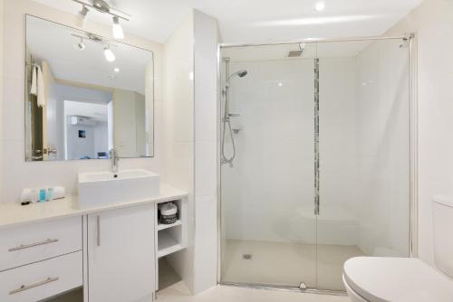 a bathroom with a shower and a toilet and a sink at Bright 2-Bed with Pool, Spa & Tennis Court in Gold Coast