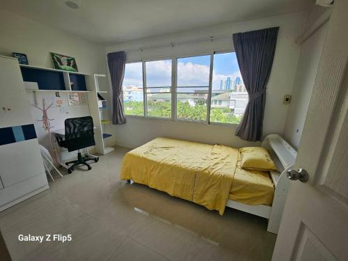 a bedroom with a bed with a yellow bedspread and a window at 98/61 home in Ban Khlong Prawet