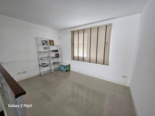 a living room with a window and a tile floor at 98/61 home in Ban Khlong Prawet