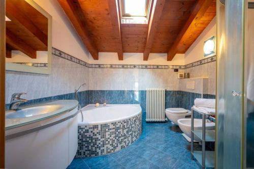 a bathroom with a tub and a toilet and a sink at Art Music House Lake Como Dongo in Dongo