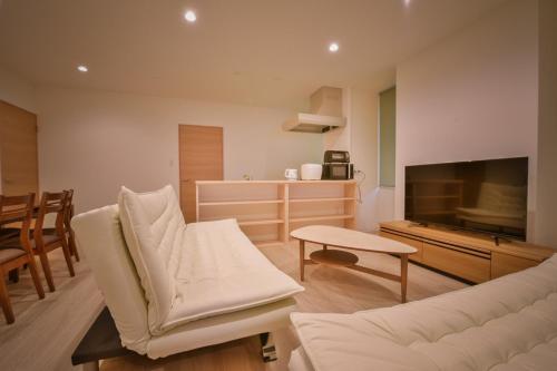 a living room with a couch and a television at Ryo An in Otaru