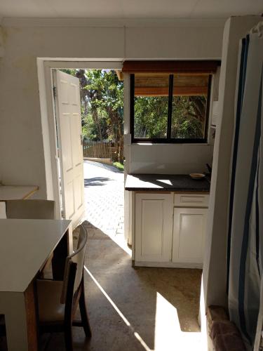 a kitchen with a door open to a yard at Ocean Walk Garrick in Zinkwazi Beach
