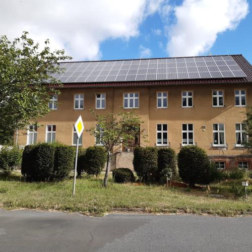 a building with solar panels on its roof at Wohnung für bis zu 4 Monteure in der Nähe von Fehrbellin in Manker