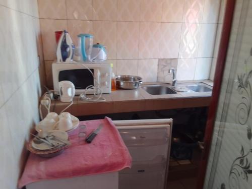 eine kleine Küche mit einem Waschbecken und einem rosa Handtuch in der Unterkunft Free Studio in Dakar