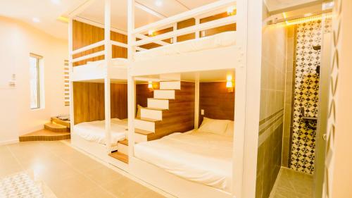 Ấp Khánh Phước (1)的住宿－Kiwi's Homestay & Cafe，一间卧室配有两张双层床。