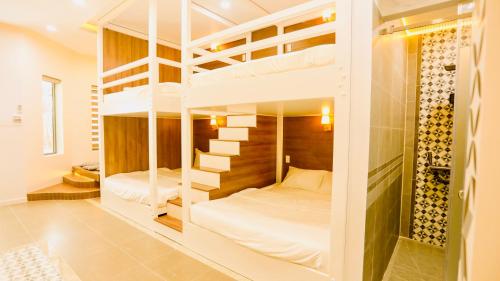 a bedroom with two bunk beds in a room at Kiwi's Homestay & Cafe in Phan Thiet