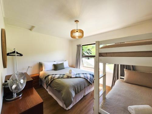 a bedroom with a bunk bed and a window at Cosy Hahei Retreat in Hahei
