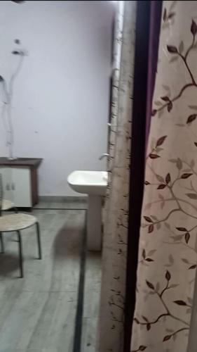 ein Bad mit einem Waschbecken und einem Duschvorhang in der Unterkunft The New Grand INN in Gorakhpur