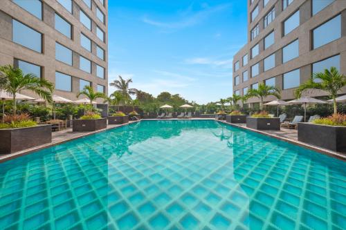 a large swimming pool in front of a building at Aurika, Mumbai Skycity - Luxury by Lemon Tree Hotels in Mumbai