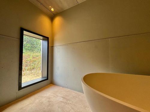 uma casa de banho com uma banheira e uma janela em Nonpura　VACATION VILLA　iriomote em Iriomote