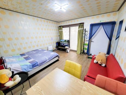 1 Schlafzimmer mit einem Bett und 2 Stühlen in der Unterkunft Jun Live Pension in Gangwha in Incheon
