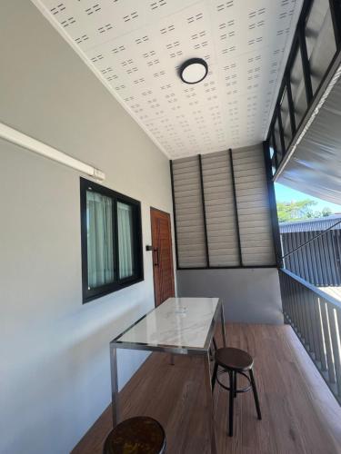 a dining room with a glass table and a stool at Pani House ( Hatyai 3 ) in Hat Yai