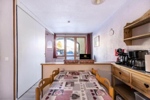 une cuisine avec une table recouverte d'une nappe dans l'établissement Résidence Le Hameau du Sauget - maeva Home - Appartement 2 pièces 4 personnes - Confort MAE-3944, à La Plagne Tarentaise