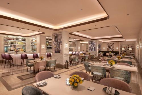 a restaurant with tables and chairs and a bar at Aurika, Mumbai International Airport - Luxury by Lemon Tree Hotels in Mumbai