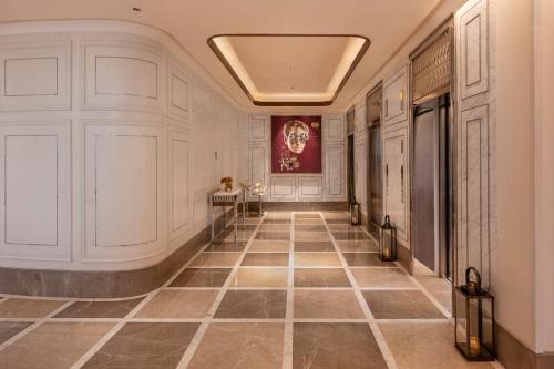 a hallway with a tile floor and a painting on the wall at Aurika, Mumbai International Airport - Luxury by Lemon Tree Hotels in Mumbai