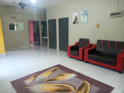 a living room with two chairs and a rug at Saffira Homestay Near Universiti Malaya Education Centre -UMEC in Bachok