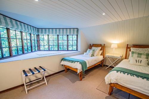 1 dormitorio con 2 camas y ventana en Crossroads Cottage, en Dullstroom