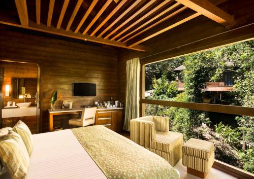 a bedroom with a bed and a view of a bathroom at The Tamara Coorg in Kakkabe
