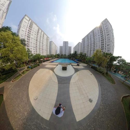 una persona que toma una foto de un parque con edificios en kalibata city en Yakarta