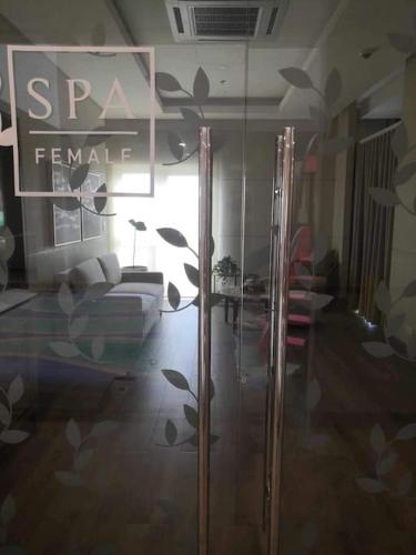 a room with a glass door with a bed in it at Saint Honore Executive 1 Full bed, 1 Sofa bed 1 Pull out bed 2BR in Iloilo City