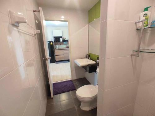 a small bathroom with a toilet and a sink at Central Comfy Airy Tidy Apartment in Udon Thani