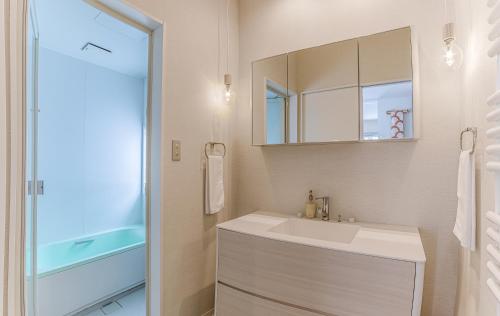 a bathroom with a white sink and a mirror at Gensei in Niseko