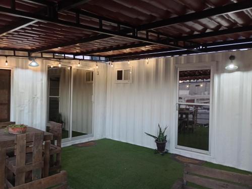 un patio esterno con prato verde e pergolato di Container-Suite a La Paz