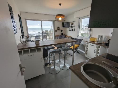 サンティレール・ド・リエにあるSt Gilles Appartement face merのカウンターとテーブルと椅子のあるキッチン