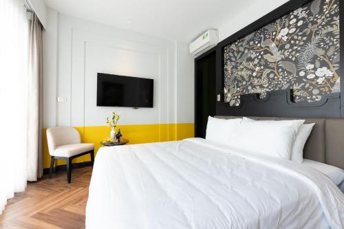 a bedroom with a large white bed and a chair at SWORD LAKE Hotel in Hanoi