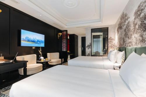 a hotel room with two beds and a tv at SWORD LAKE Hotel in Hanoi