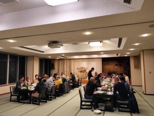 a group of people sitting at tables in a room at Kannabi Ikomayama Hotel in Ikuma