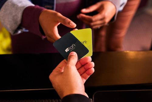 um grupo de pessoas a reter um cartão de crédito em Aloft Me'aisam, Dubai em Dubai